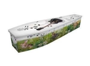 Cardboard coffin with an image of a black guitar, bunny rabbits and musical notes in a white daisy field